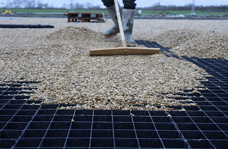 An image of gravel being pushed by someone