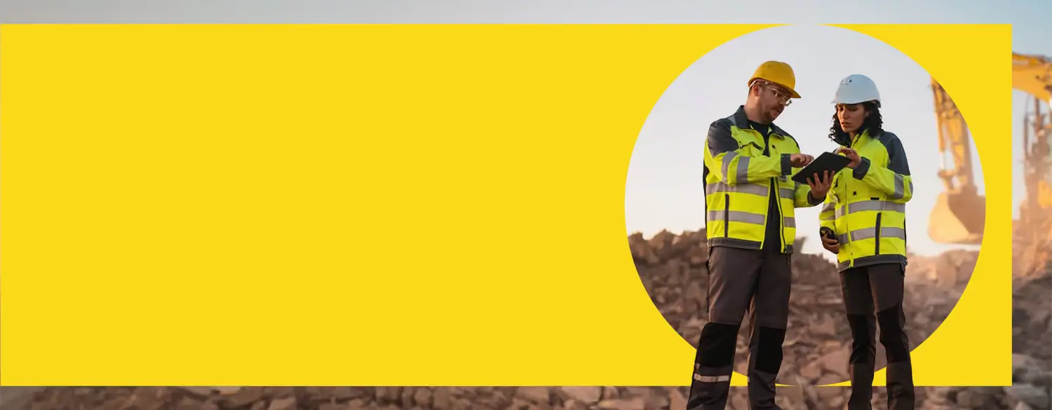 Image of two people in hi-vis jackets looking at a clip board